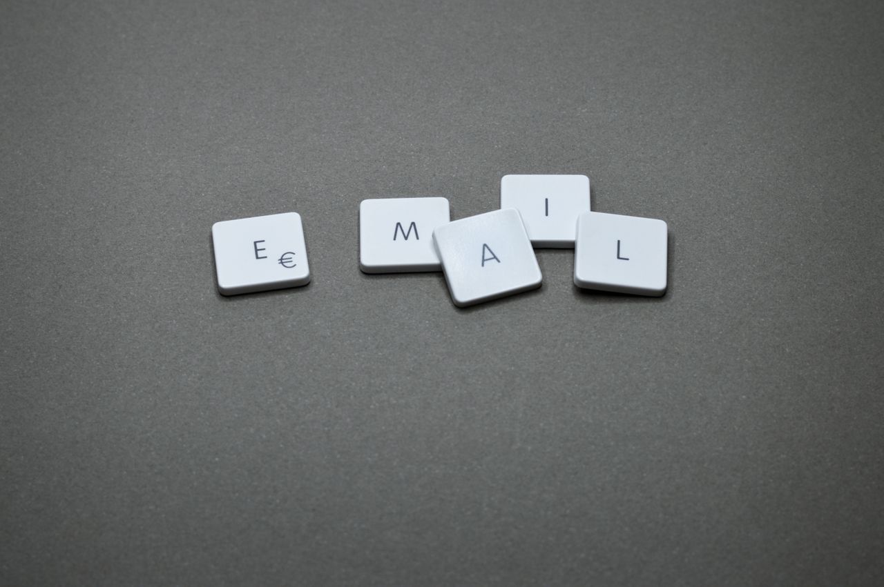 Gros plan sur le mot email composé de lettres sur une surface grise.